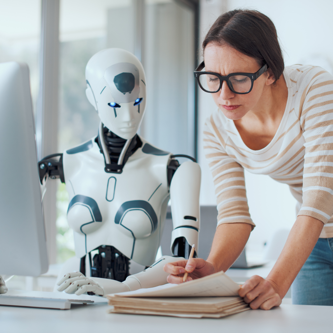 Woman collaborating with humanoid robot at desk.